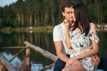 Young loving couple hugging near lake.