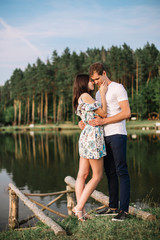 Young loving couple hugging near lake.