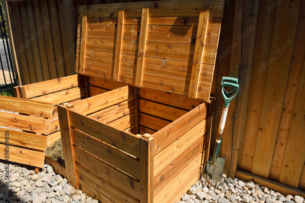 Wall mural two bin organic composter made of cedar wood with open lid and removed front for yard waste beside f