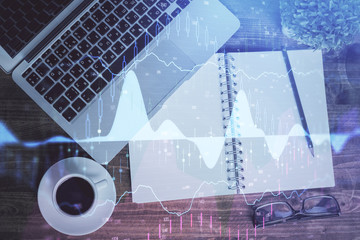 Financial market graph and top view computer on the desktop background. Double exposure. Investment concept.