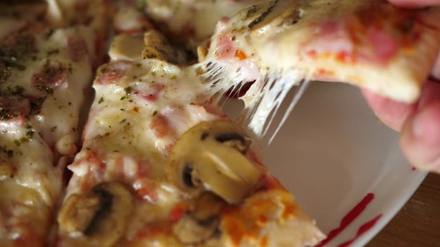 taking slice of pizza with super stretching stretchy cheese