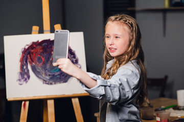 a young charming artist leads an online masterclass in drawing pictures in her workshop