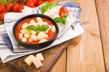 Homemade Italian Gnocchi with Red Sauce, Cheese with basil, olive oil . Close up. Home cooking. Traditional Italian cuisine from Rome and Sardinia. Plate of food for the first