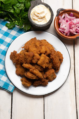 Fish chicharron with mayonnaise and onion on white background