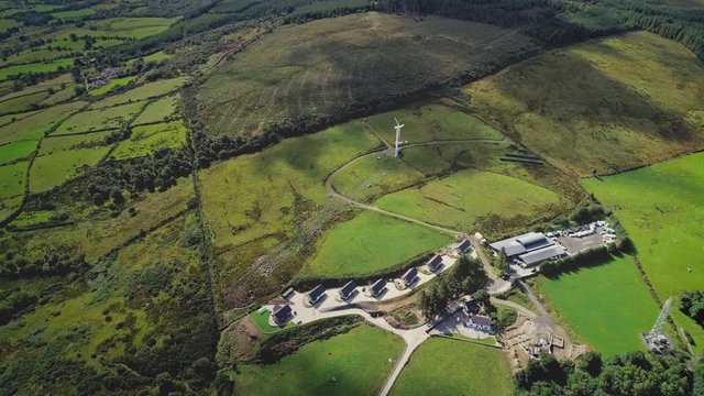 Wind generator top-down aerial view. Renewable electricity: alternative power plant, solar panels with of Irish farmland at Ballycastle port town, Northern Ireland. Footage shot in 4K, UHD