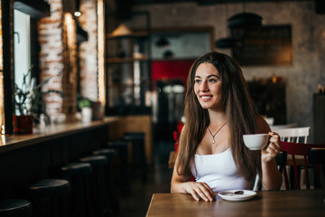 Beautiful woman drinking coffee sitting in a cafe.
