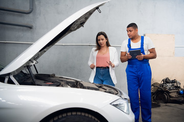 Woman explains to the mechanic the cause of the car breakdown