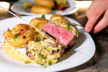 Juicy cut beef steak. The cook showing the readiness of the meat.