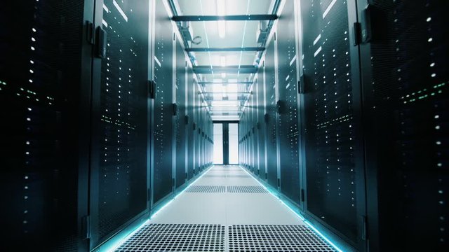 Network and data servers behind glass panels in a server room of a data center or ISP. Forward Dolly Shot