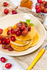 Stack of Pancakes with Sliced Red Grapes and Maple Syrup for breakfast. Selective focus.