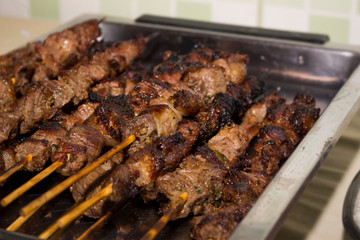 Skewers of beef roasted on the grill warm and served on a tray.