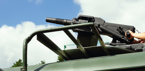 Military army vehicle with machine gun for aiming and shooting, close up