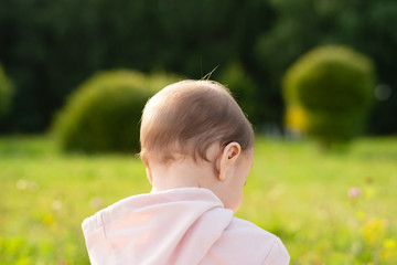blurred image of child from  back, background from park and trees, conceptual image