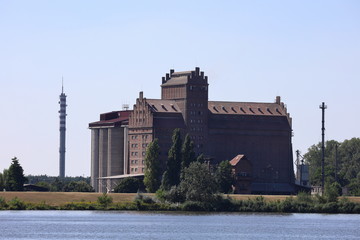 an old granary by the river hung in Płock - obrazy, fototapety, plakaty