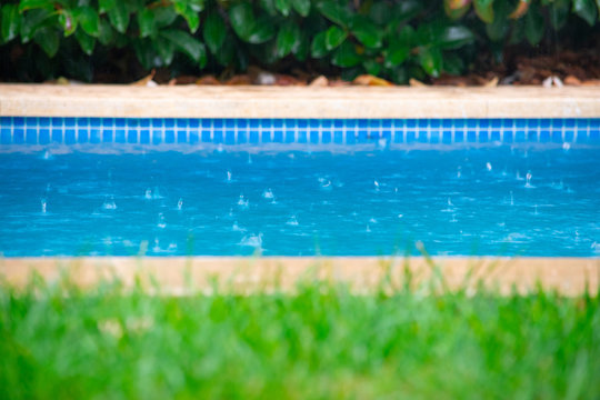 Close up of rain drops falling in the swimming pool.