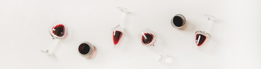 Red wine in glasses. Flat-lay of wine glasses with red wine in row over plain white background, top...