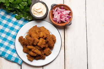 Fish chicharron with mayonnaise and onion on white background