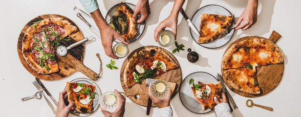 Pizza party for friends or family. Flat-lay of various pizzas, drinks and people celebrating over plain white table background, top view. Fast food, comfort food, Italian cuisine concept