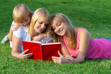 Fototapeta premium happy family in nature reading a book