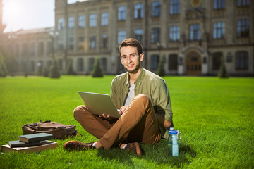 Obraz premium Pleased young man with a laptop in his hands