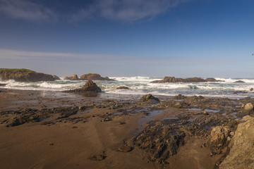 Fototapeta na wymiar Waves breaking on rocks on the beach
