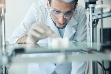 Contented engineer looking at the three-dimensional object