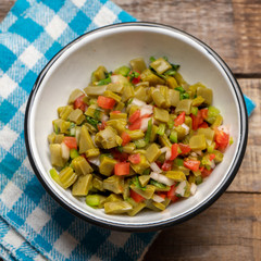 Mexican nopal cactus salad on wooden background