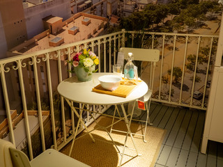 Mesa en una terraza blanca con flores 