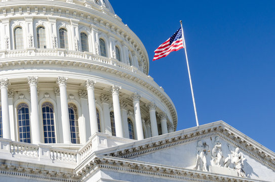 United States Capitol Building dome detail and waving U.S. National flag  - Washington D.C. United States of America