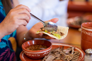 unrecognizable person eats a delicious Mexican taco