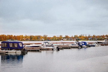 Fototapeta premium Boats at the pier in the autumn on cloudy afternoon.