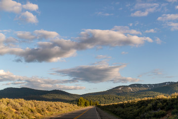 An empty road with clouds and hills