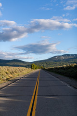 An empty road with clouds and hills