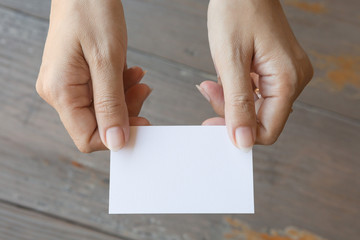 Hand holding Business card  on a wood background