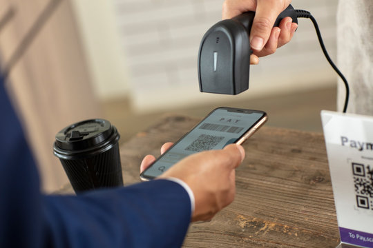 キャッシュレス決済のスマートフォンとバーコードリーダー