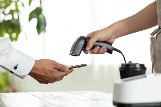 キャッシュレス決済のスマートフォンとバーコードリーダー