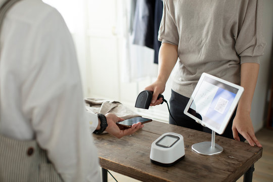 キャッシュレス決済をする客と店員