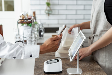 キャッシュレス決済をする客と店員