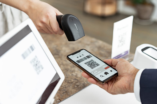 キャッシュレス決済のスマートフォンとバーコードリーダー