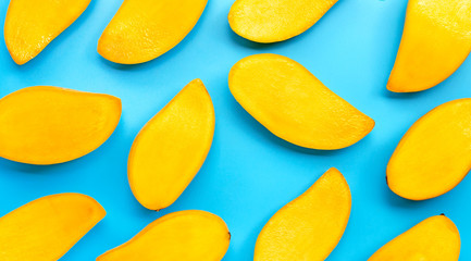 Tropical fruit, Mango slices on blue background.