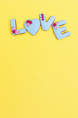 Painted gingerbread in shape of word love. Postcard minimal style. Holiday food concept.  Flat lay with pastel colos.