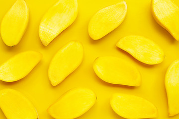 Tropical fruit, Mango slices on yellow background.