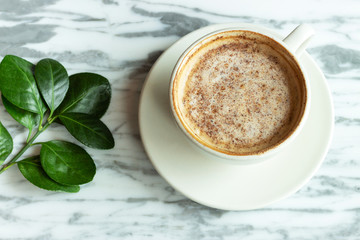 A white cup of coffee on marble background, close-up