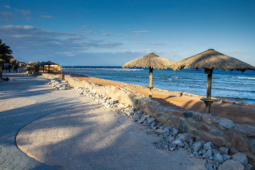 The row of sunshades on the sandy beach.
