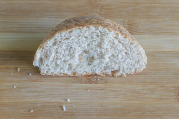 a piece of bread with bran close-up on a wood board  