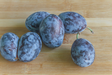 large plums close-up on a wooden board 