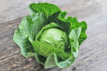 Colorful of Fresh Green cabbage with water drop on wooden background.