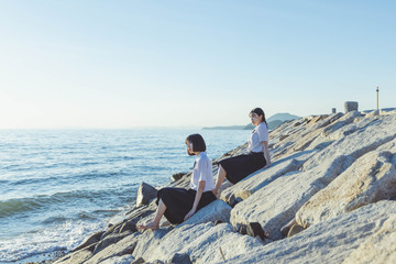 夕暮れの海にいる女子高生