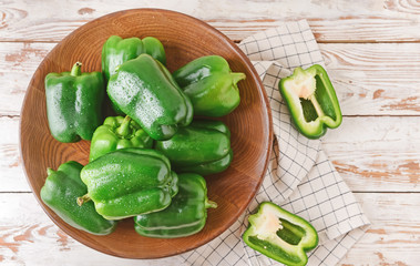 Plate with green bell pepper on table