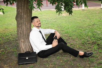 Handsome businessman relaxing in park